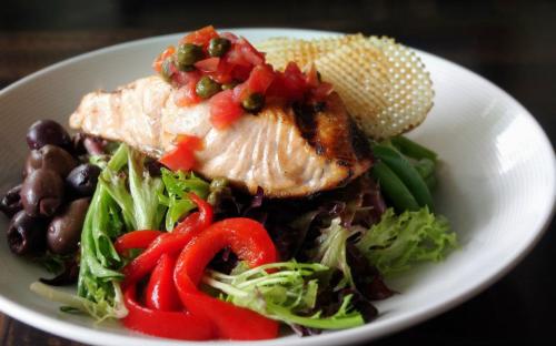 Artisan greens with grilled salmon, green beans, hardboiled egg, gaufrette potatoes, olives, tomato, and capers tossed with lemon vinaigrette